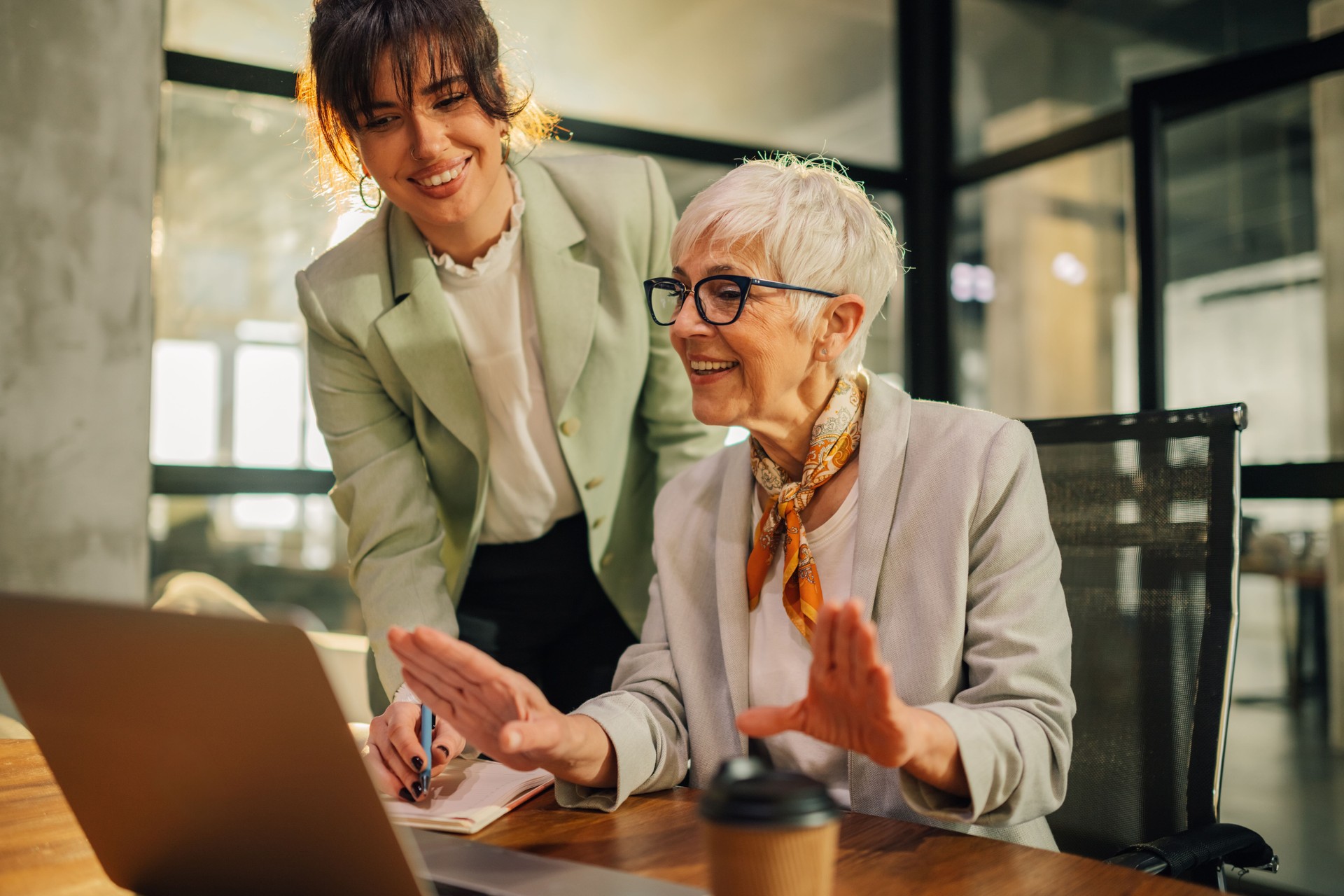 A smart senior executive coaching her younger colleague at the office.